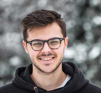 a guy with glasses on a snowy street